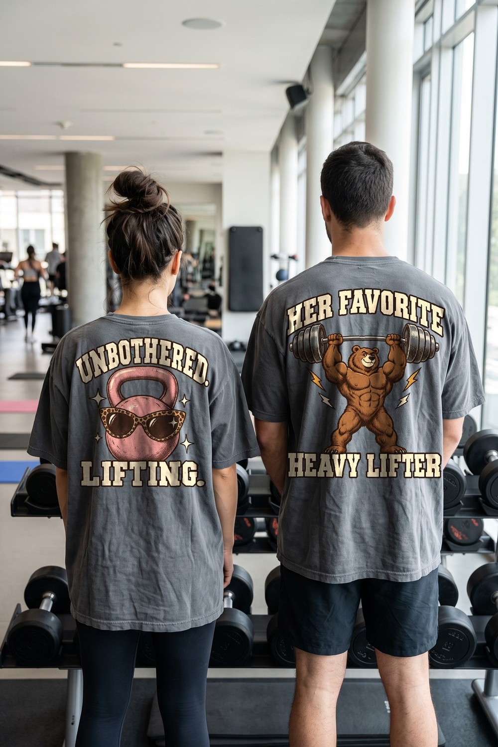 Couple at the gym wearing Unbothered Lifting and Her Favorite Heavy Lifter oversized tees