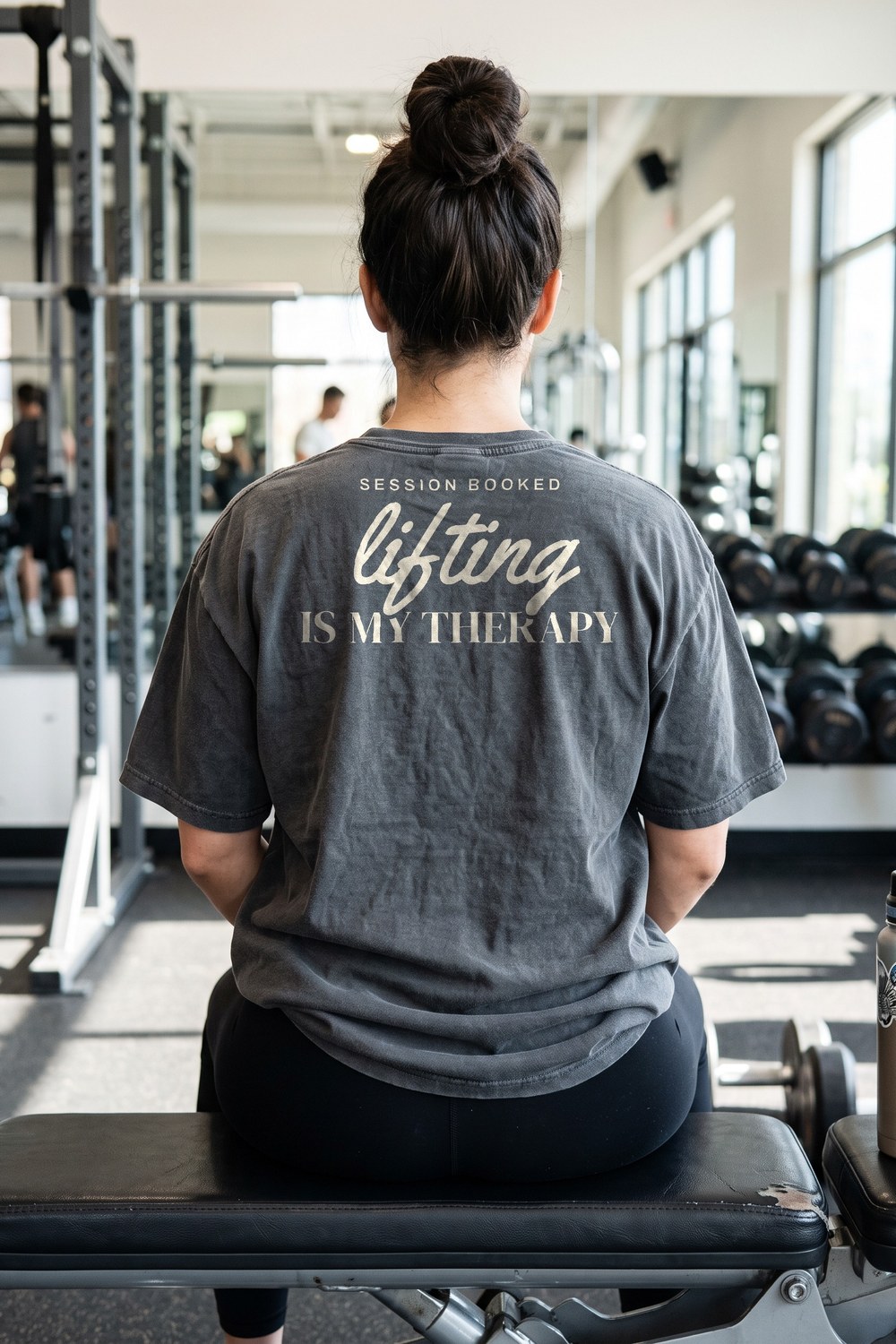Woman resting on a gym bench in a Lifting Is My Therapy oversized tee